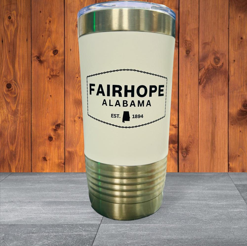 A 20oz. Stainless Tumbler with Silicone Grip labeled "Fairhope Alabama Est. 1894" against a wooden background, featuring double-wall vacuum insulation for optimal temperature control.