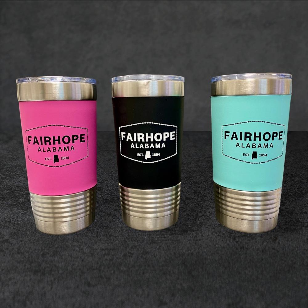 A set of three 20oz. Stainless Tumblers with Silicone Grip, available in pink, black, and teal colored sleeves, each adorned with "Fairhope Alabama" and "Est. 1894" on a gray background and featuring double-wall vacuum insulation.