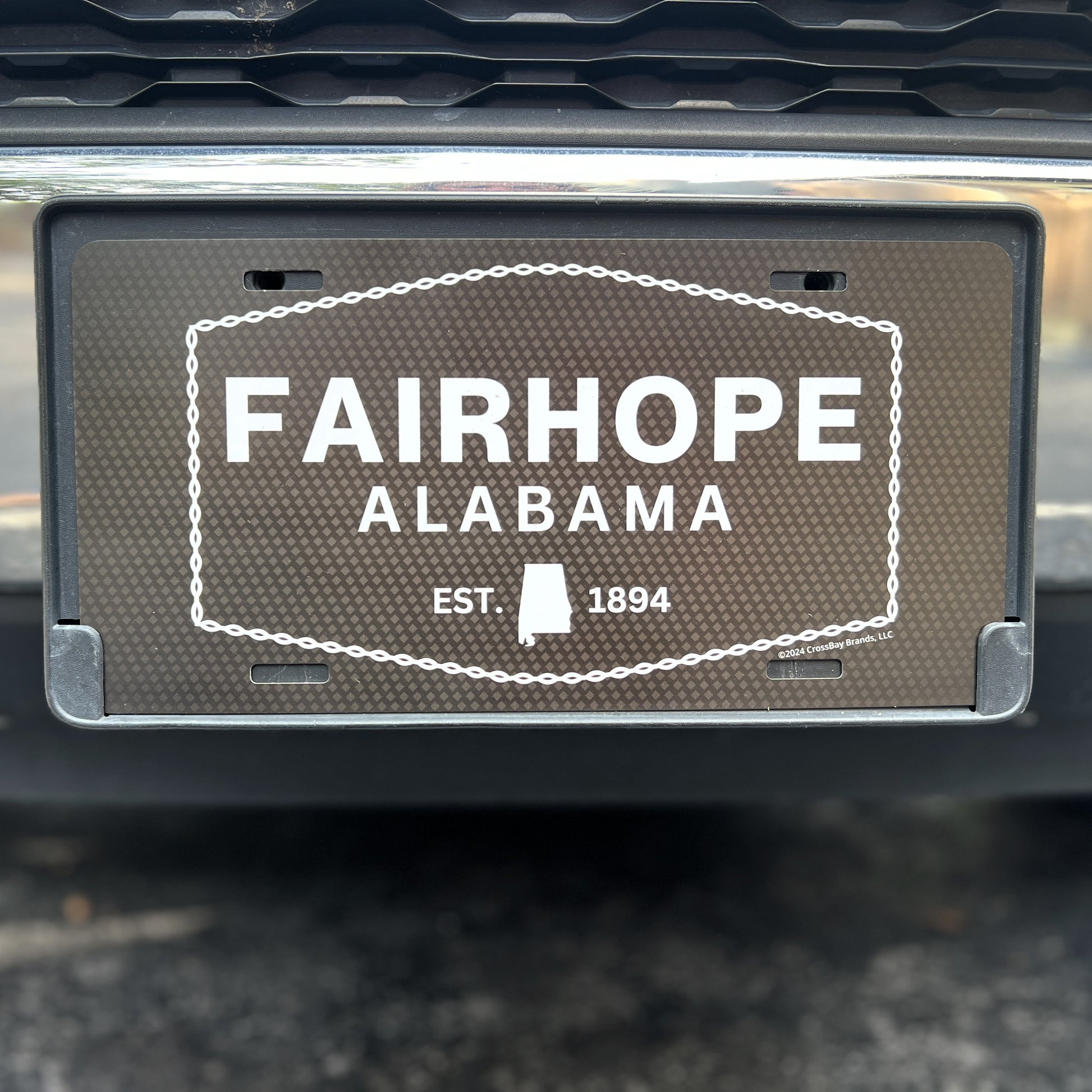 A vehicle proudly displaying the "Fairhope Heritage - Car Tag," a UV printed aluminum license plate frame featuring the text “Fairhope, Alabama EST. 1894.”