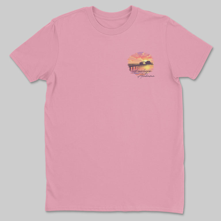 Product Description: Fairhope Sunset - Tee in pink features a small graphic on the left chest depicting a sunset, Fairhope Pier, and the text "Welcome to Alabama.